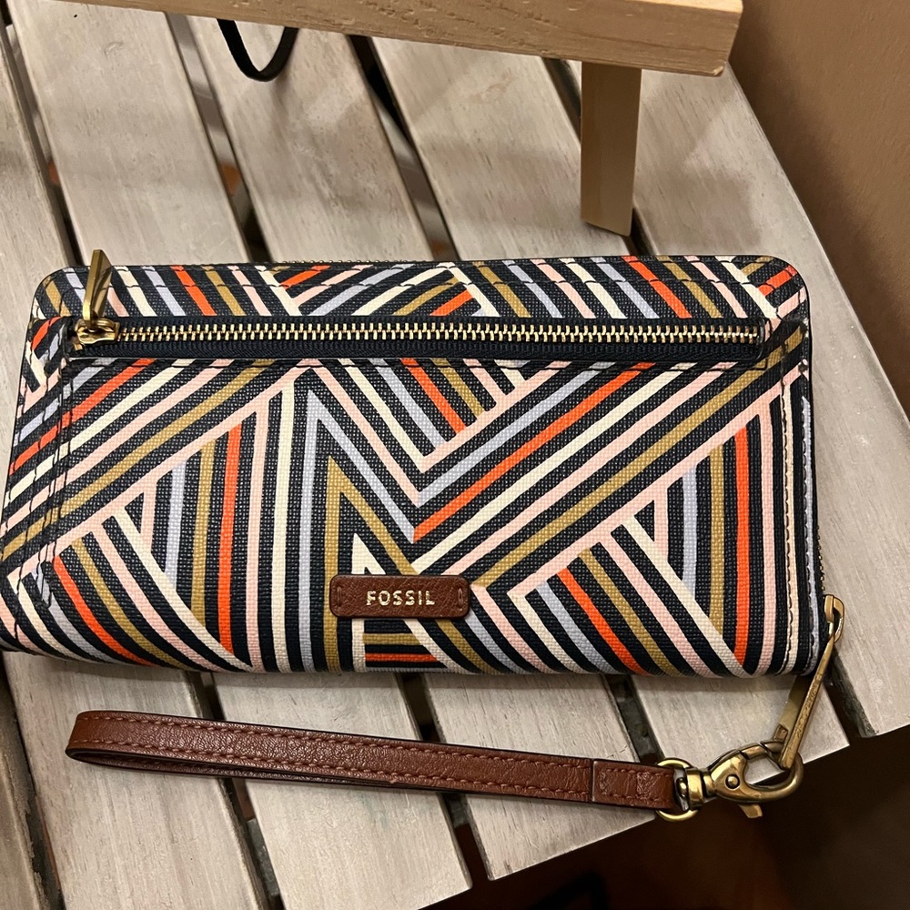 A beautiful colorful fossil wallet with brown leather slides for credit cards.